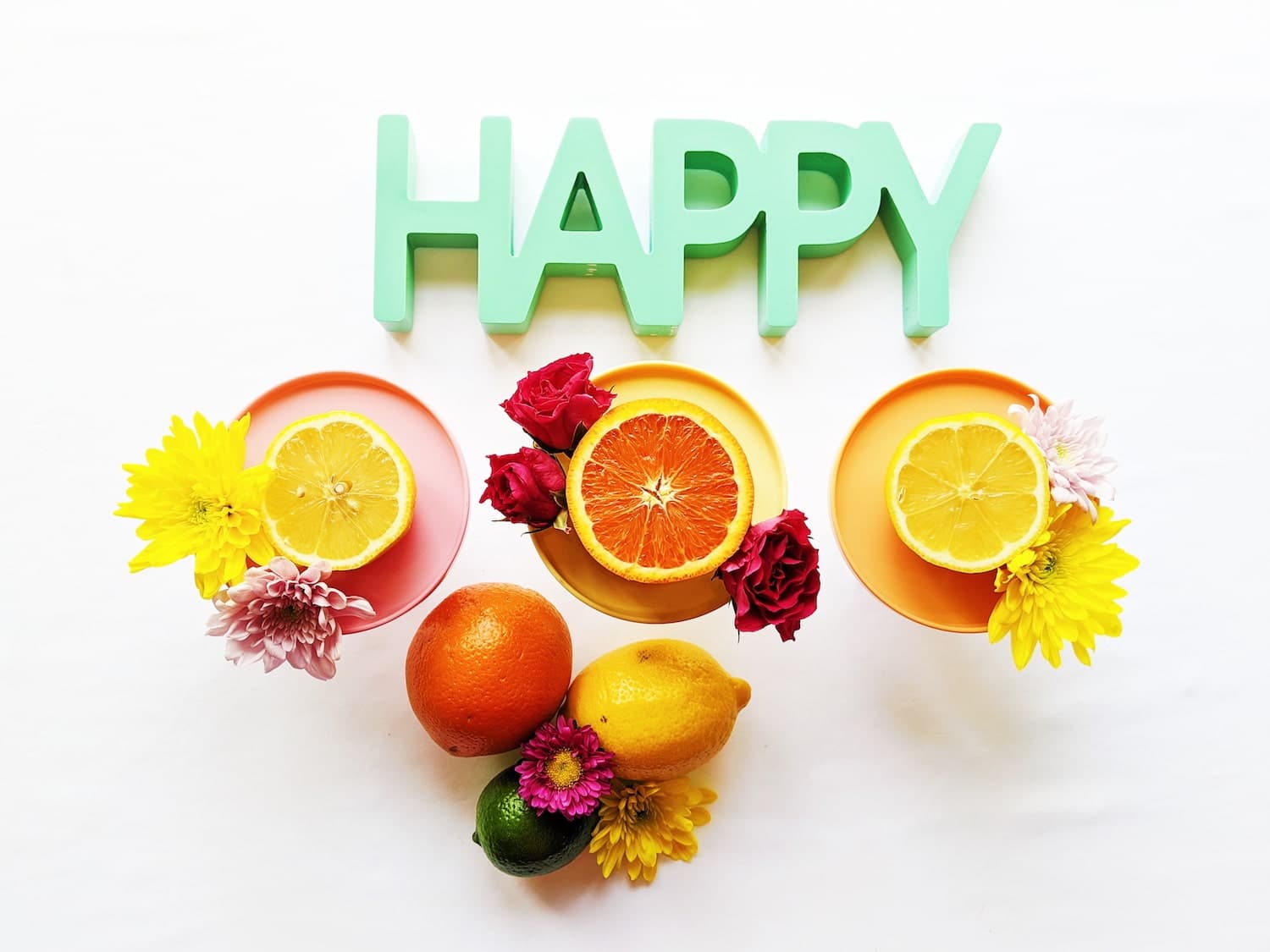 A colorful display of fruit slices and flowers arranged around the word "HAPPY."